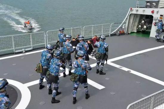 海军官兵在义乌舰上操演临检拿捕部署。
