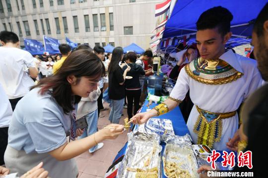 当天，每个国家的美食摊位都聚集了大量的“吃货”，学生们还相互喂食，希望身边人都能体验到世界各国的美食文化。　张瑶 摄