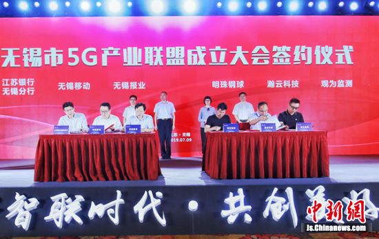 图为联盟成立大会现场的签约环节。