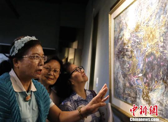 7月13日，台湾师范大学、华侨大学作品交流展在台湾师范大学德群画廊举办。图为观展者在展览现场讨论画作。　刘舒凌 摄