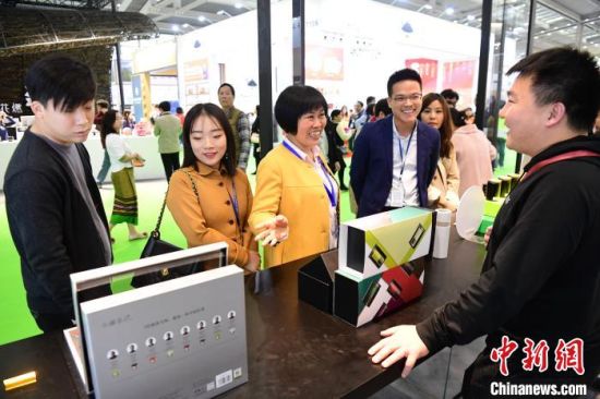 图为客商关注小罐茶。　陈文 摄