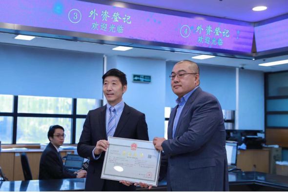 上海市市场监管局局长陈学军为中国自然人投资外资企业颁发首张营业执照。 上海市市场监管局 图
