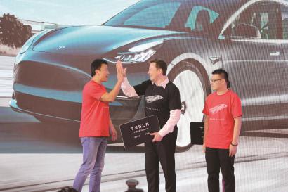 昨天，特斯拉中国制造Model 3开启全面交付，马斯克（中）向首批社会车主代表交付车辆。 本报记者 祝越摄
