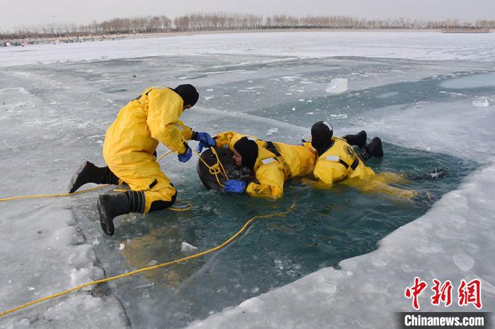 图为参训指战员结合培训内容现场开展冰面救人救助与自我救援演练。　罗凯 摄