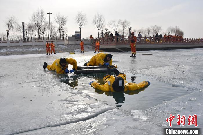 图为参训指战员进行冰面救人救助与自我救援演练。　罗凯 摄