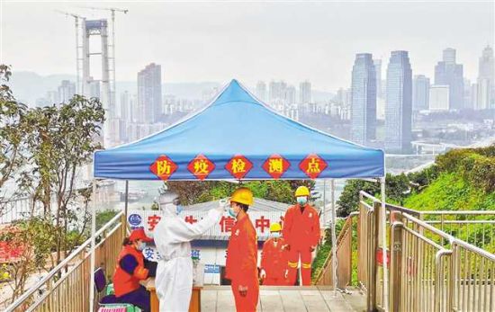 二月二十九日，在中铁隧道三处重庆轨道交通十号线二期七星岗项目部，工人们正拉开间距排队测量体温后进入工地。通讯员 周勇 摄