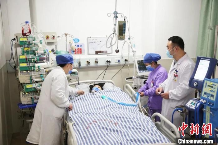 图为医护人员正在查看患者病情。　江西省人民医院供图 摄