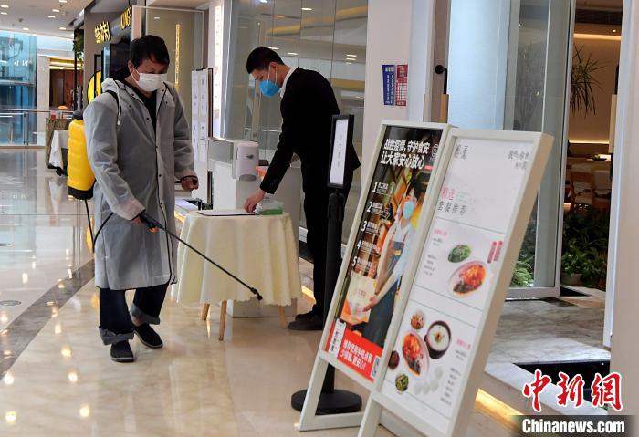 图为福州仓山万达广场工作人员正在对恢复堂食的餐厅进行外围消杀作业。　张斌 摄