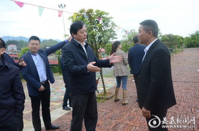 （吴建平和蓝莓谷生态旅游度假区负责人进行交流）