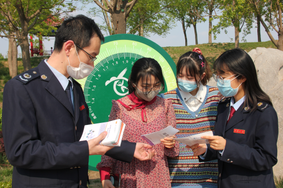 景县税务局深入地方景点董子公园开展政策宣传活动。图为税务干部正在向创业大学生解读税费优惠政策。 安宝光 摄