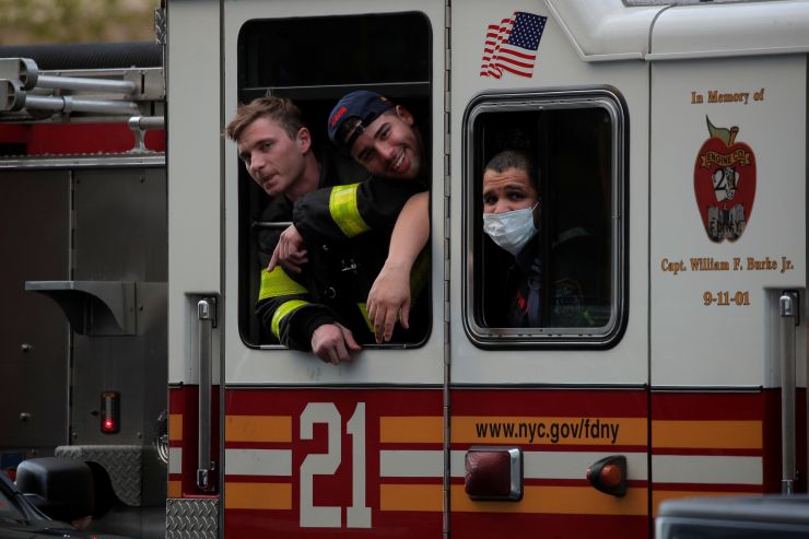 4月20日，纽约市消防局（FDNY）成员在曼哈顿第一大道的纽纽约大学朗格尼医学中心外向医护人员欢呼致谢。（图片来源：路透社）