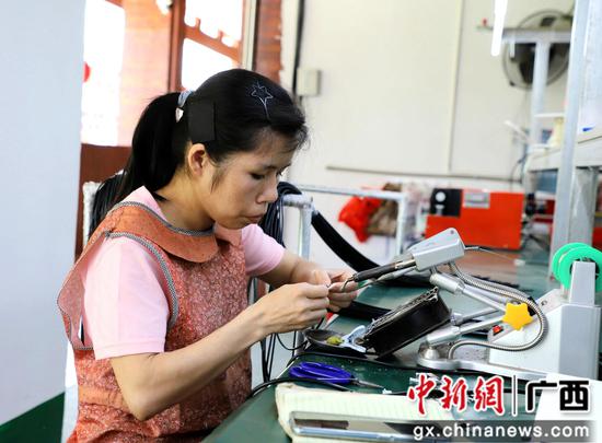 陆培燕在扶贫车间加工电子配件。