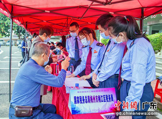 梅江区东升工业园区开放日活动上，税务人员宣传疫情防控和复工复产等优惠政策。梅江区税务局供图