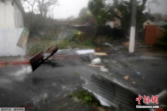 在波多黎各瓜亚马，大风卷起建筑碎片四处扫荡，减弱为四级飓风的“玛利亚”破坏力依然巨大。