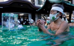 日本民众戴口罩泡冰水浴祈祷新冠疫情结束